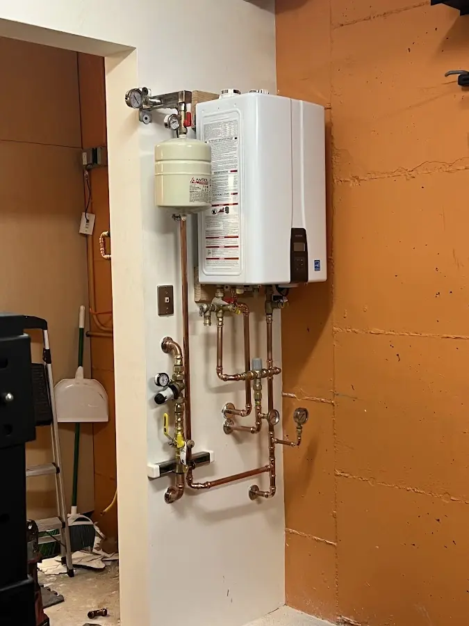 Plumbing technician inspecting water heater connections in Buckingham